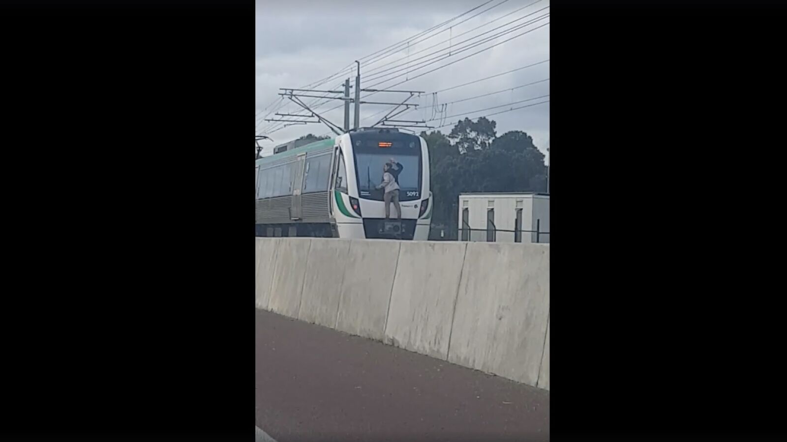 Pillan a un hombre viajando en la parte trasera de un tren agarrado a los limpiaparabrisas