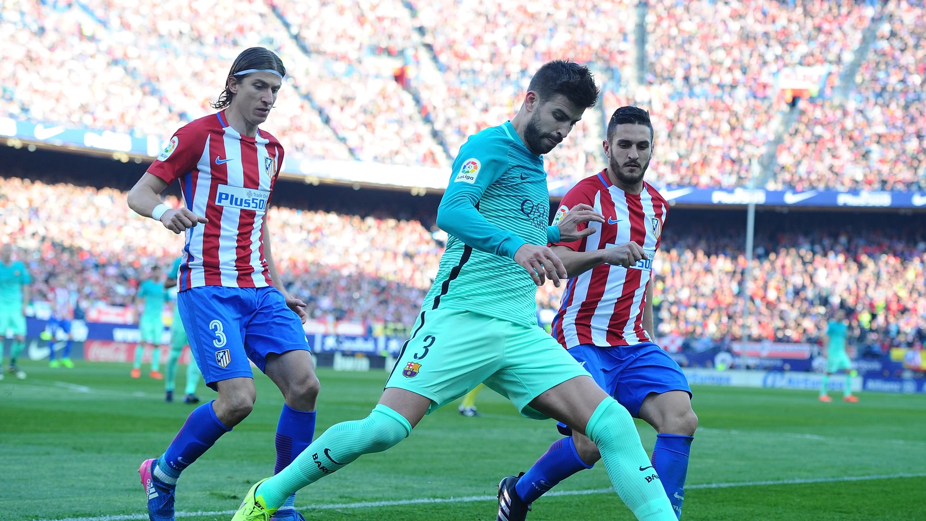 Piqué intenta despejar el balón ante la presión de Filipe Luis y Koke Piqué intenta despejar el balón ante la presión de Filipe Luis y Koke