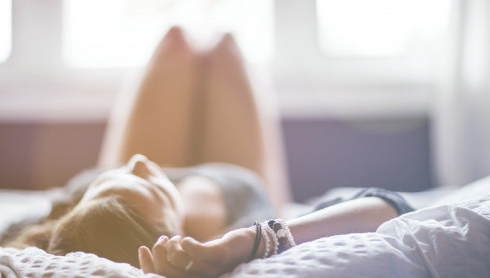 Una mujer tumbada sobre una cama