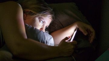 Mujer durmiendo con móvil