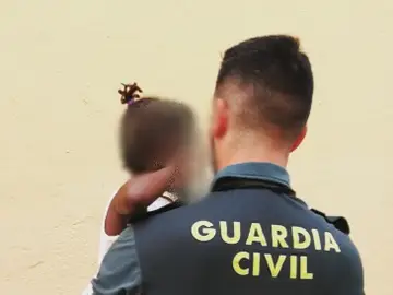La niña en brazos de un Guardia Civil La niña en brazos de un Guardia Civil
