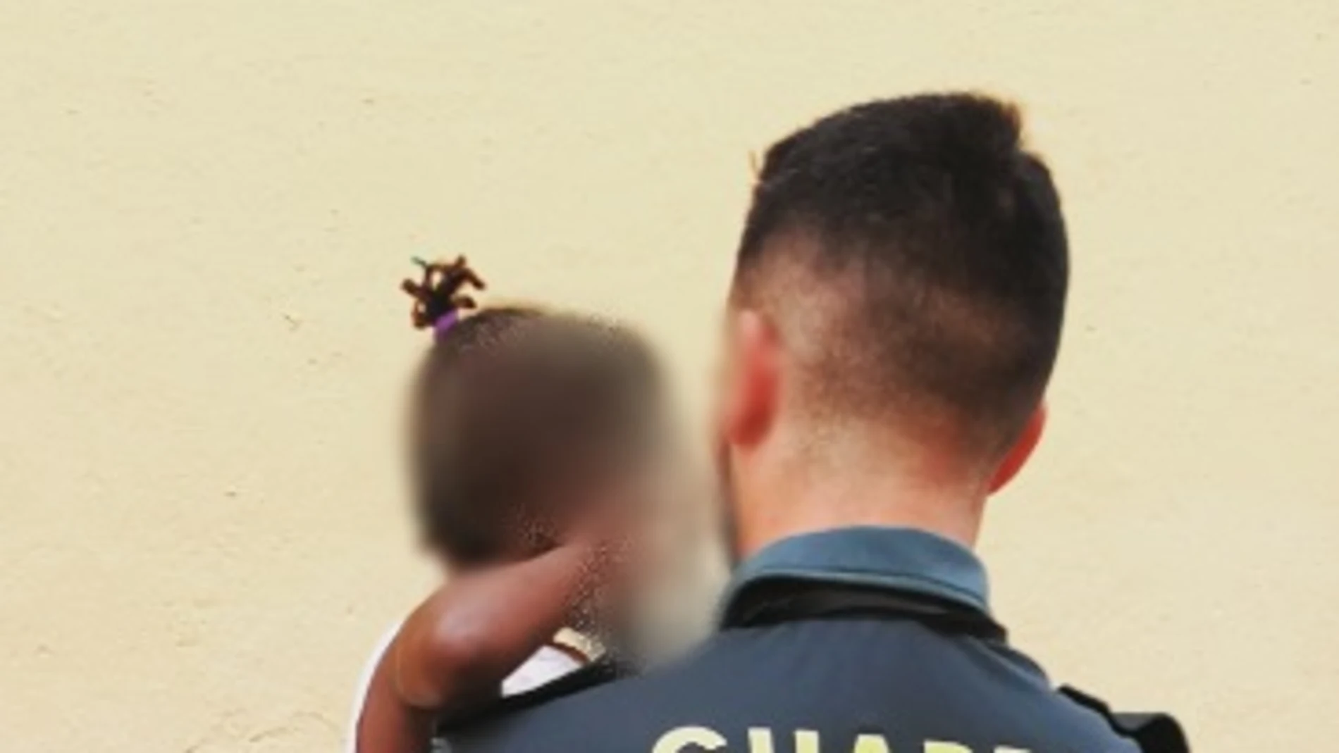 La niña en brazos de un Guardia Civil La niña en brazos de un Guardia Civil