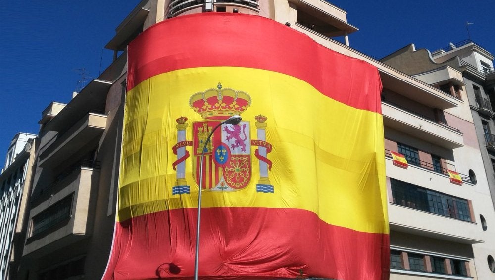 Gran bandera de España colgada en la fachada del Teatro Barceló