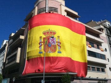 Gran bandera de España colgada en la fachada del Teatro Barceló