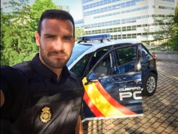 Saúl Craviotto posa con su uniforme de Policía al lado de un coche patrulla