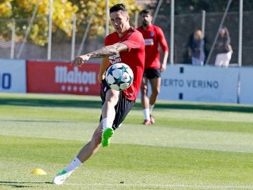 Torres patea un balón bajo la mirada de Diego Costa