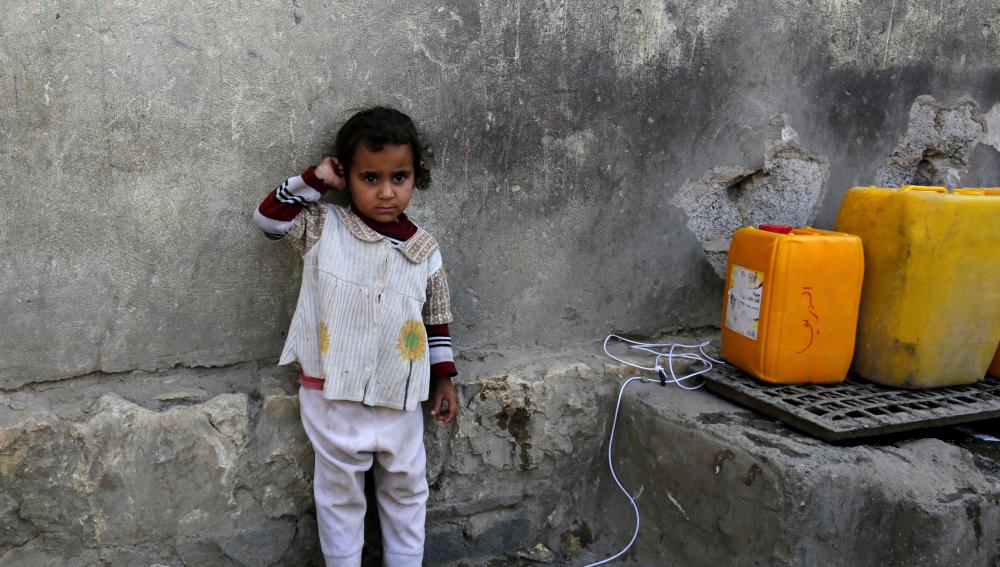 Una niña yemení espera para llenar sus garrafas de agua potable en Saná
