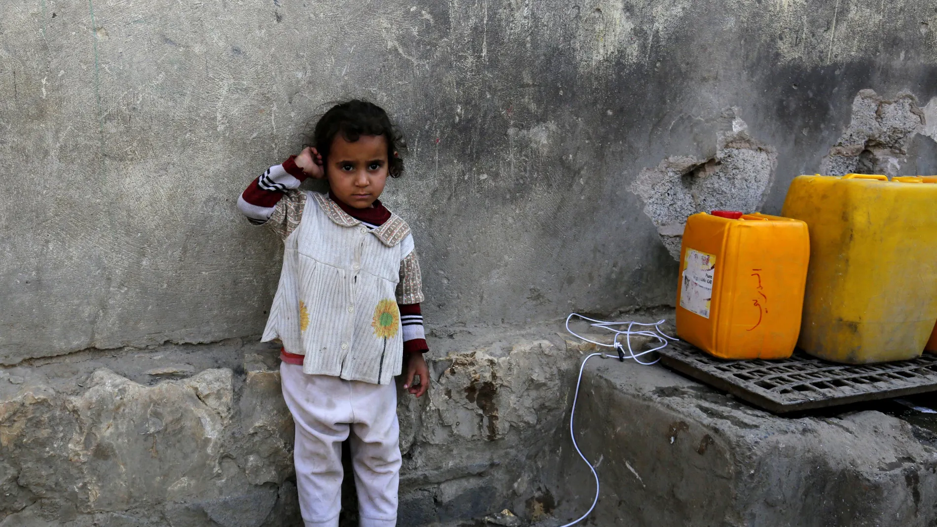 Una niña yemení espera para llenar sus garrafas de agua potable en Saná Una niña yemení espera para llenar sus garrafas de agua potable en Saná