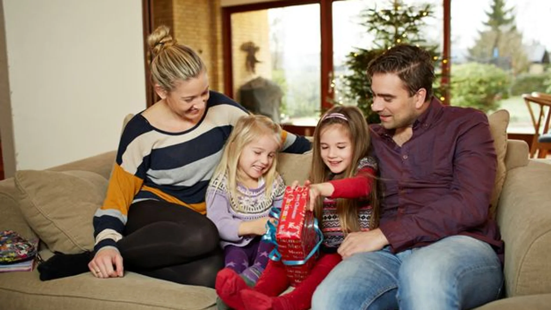 Una familia abriendo regalos Una familia abriendo regalos