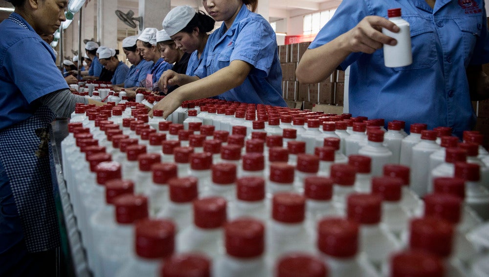 Trabajadores chinos organizando botellas de baijiu