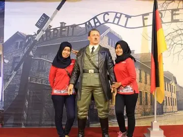 Dos mujeres haciéndose una foto con la estatua de Hitler Dos mujeres haciéndose una foto con la estatua de Hitler
