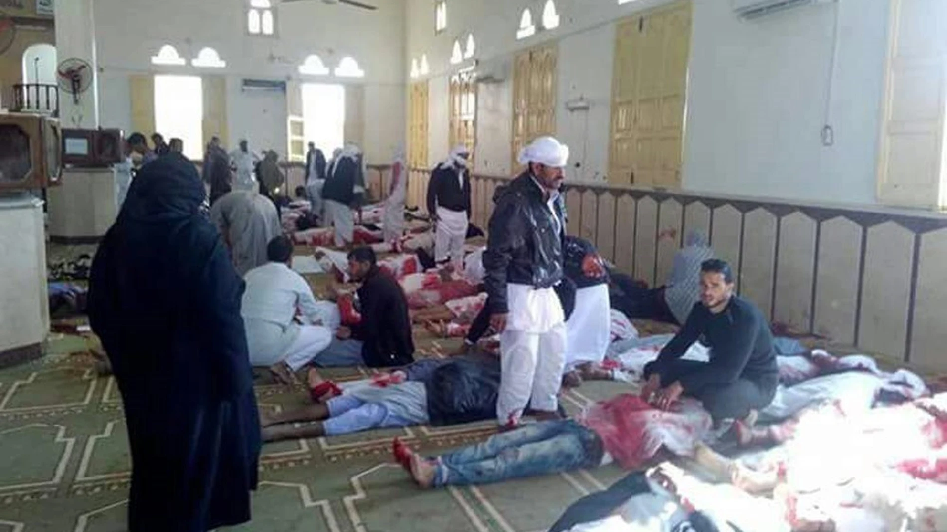 Varias personas permanecen junto a cuerpos sin vida en el interior de la mezquita atacada en Egipto