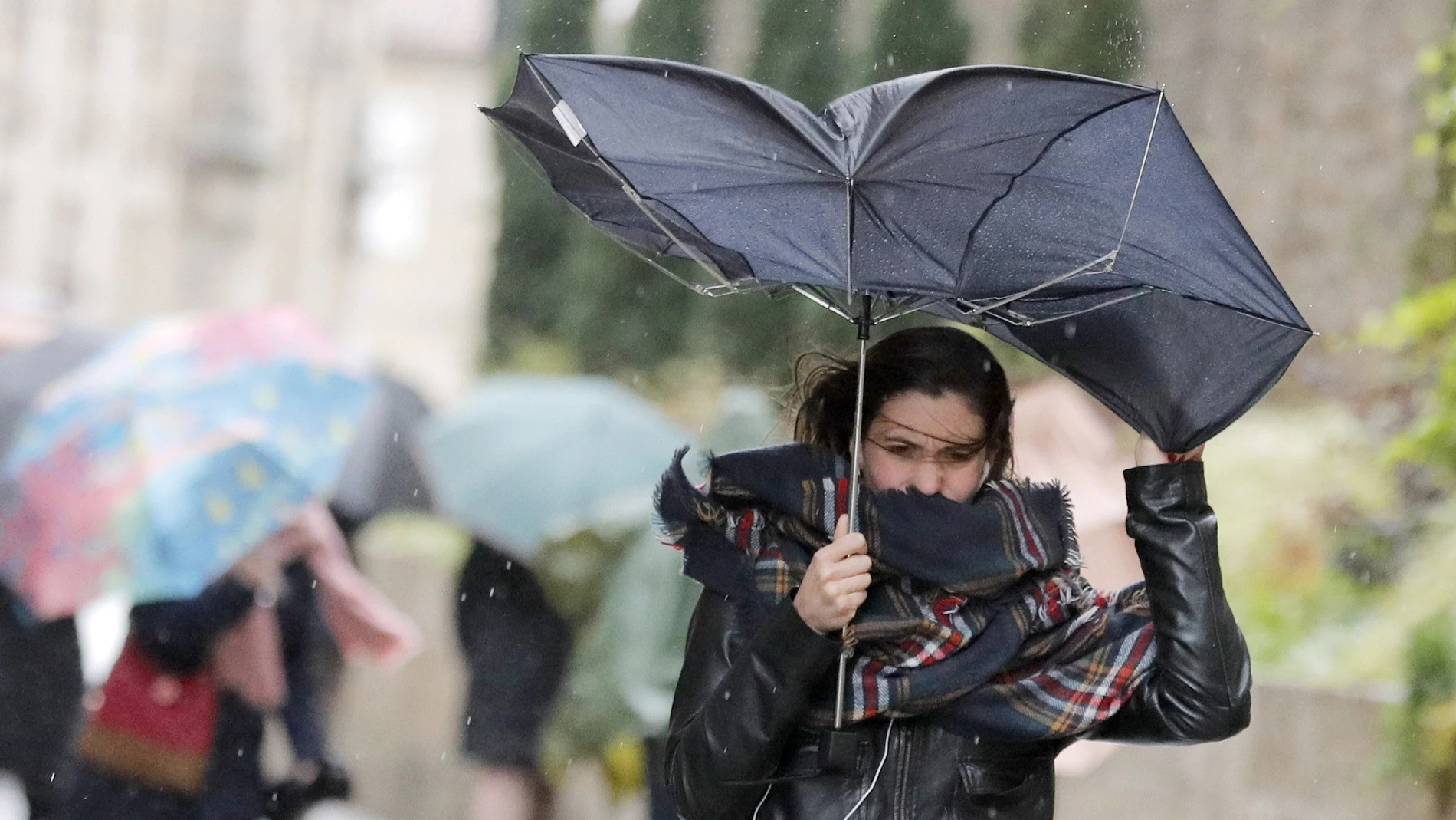 Una mujer combate los fuertes vientos y la lluvia Una mujer combate los fuertes vientos y la lluvia