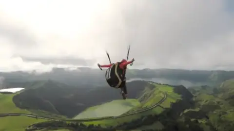 El hombre tirándose en parapente El hombre tirándose en parapente