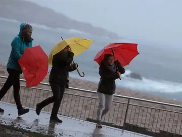 Tres mujeres se protegen de la lluvia en el paseo marítimo de A Coruña Tres mujeres se protegen de la lluvia en el paseo marítimo de A Coruña