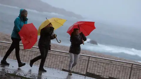 Tres mujeres se protegen de la lluvia en el paseo marítimo de A Coruña Tres mujeres se protegen de la lluvia en el paseo marítimo de A Coruña