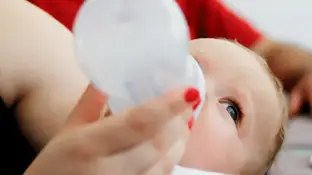 Un bebé tomando un biberón de leche Un bebé tomando un biberón de leche