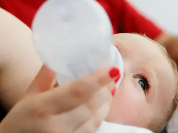 Un bebé tomando un biberón de leche Un bebé tomando un biberón de leche