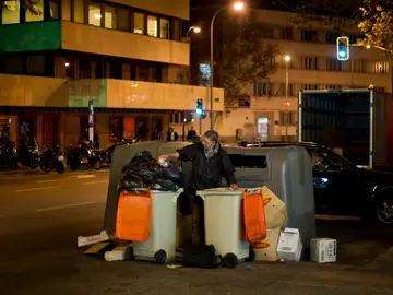 Un hombre buscando entre la basura Un hombre buscando entre la basura