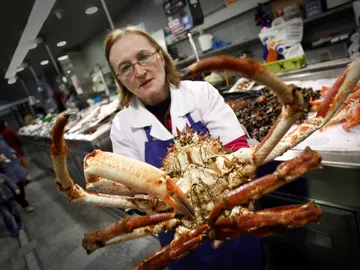 Una pescadera sostiene una centolla en el mercado de la Plaza de Lugo Una pescadera sostiene una centolla en el mercado de la Plaza de Lugo