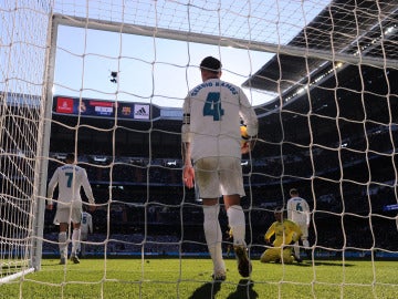 Sergio Ramos recoge un balón del fondo de la portería en El Clásico