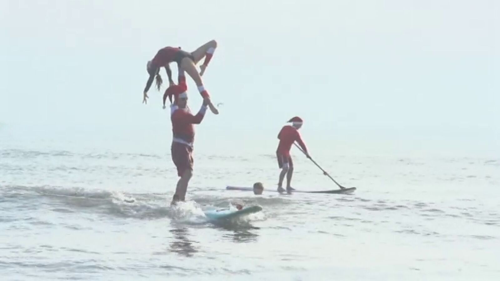Cerca de 1.000 Papás Noel invaden la costa de Florida para surfear 