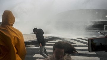 Varias personas son sorprendidas por una ola en el Paseo Nuevo de San Sebastián