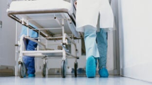 Un m&eacute;dico lleva una camilla en un hospital