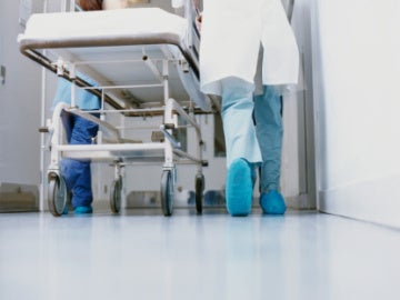 Un médico lleva una camilla en un hospital