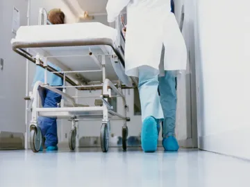 Un médico lleva una camilla en un hospital Un médico lleva una camilla en un hospital