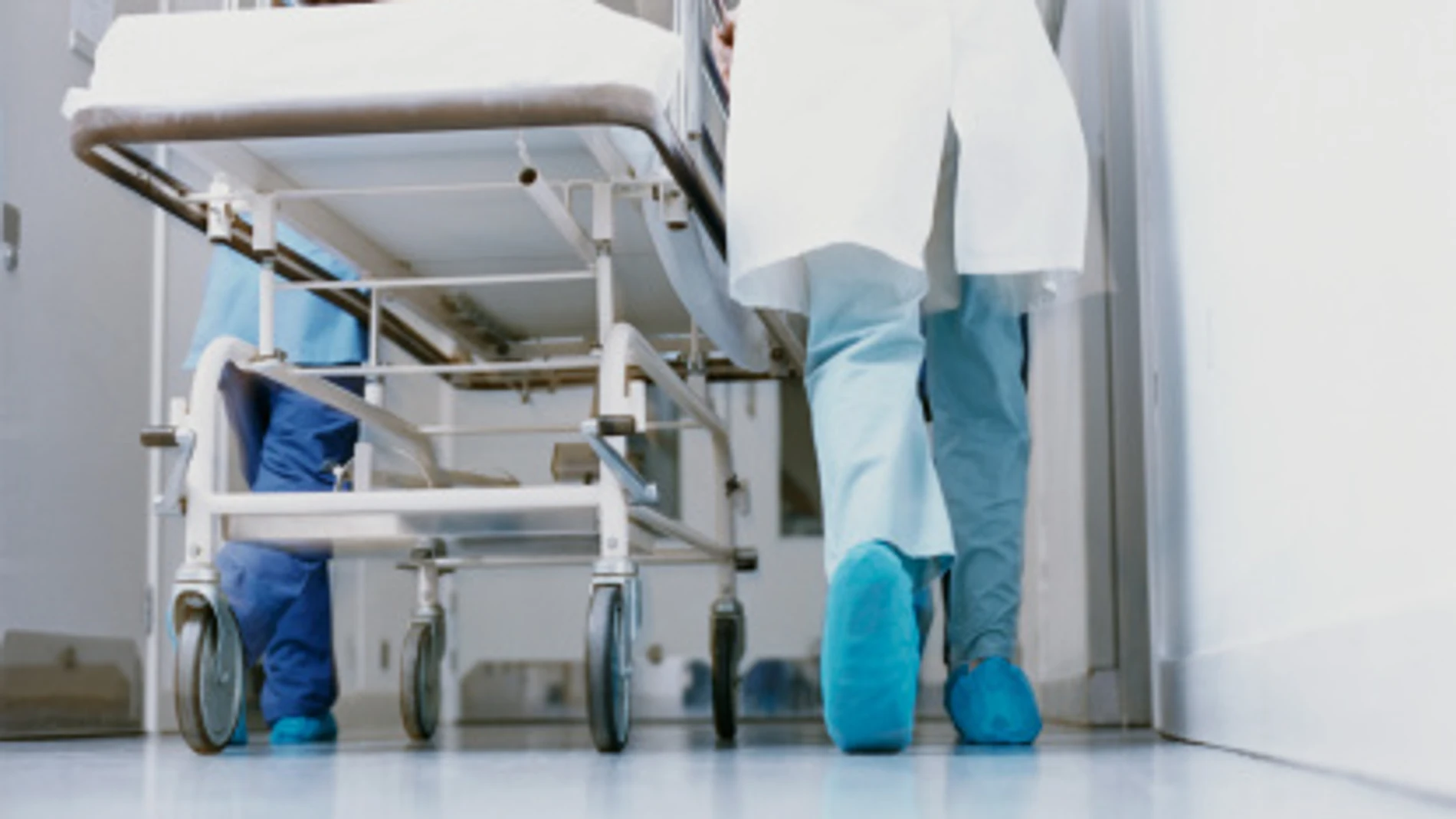 Un médico lleva una camilla en un hospital Un médico lleva una camilla en un hospital