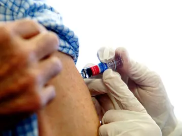 Una enfermera administra la vacuna de la gripe Una enfermera administra la vacuna de la gripe