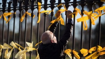 Un hombre coloca lazos amarillos en la verja del Pac de la Ciutadella (Archivo)