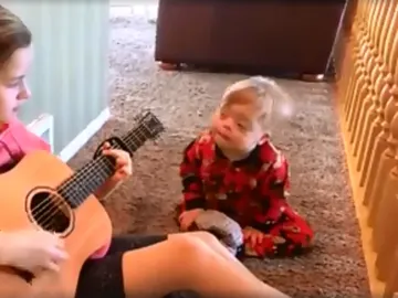 Una niña canta a su hermano con síndrome de Down Una niña canta a su hermano con síndrome de Down