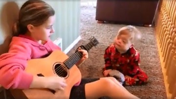 Una niña canta a su hermano con síndrome de Down
