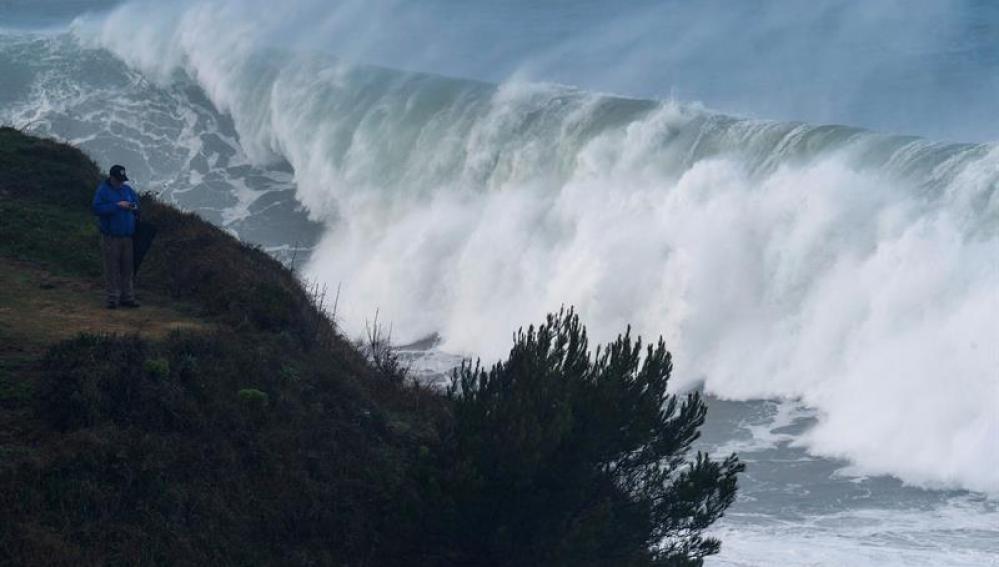 Un hombre fotografía las grandes olas que rompen ayer en la costa de la capital cántabra