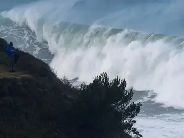 Un hombre fotografía las grandes olas que rompen ayer en la costa de la capital cántabra Un hombre fotografía las grandes olas que rompen ayer en la costa de la capital cántabra