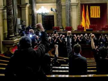 Los diputados de la CUP en sus escaños del Parlament a la hora prevista para iniciarse el pleno de investidura del próximo presidente de la Generalitat