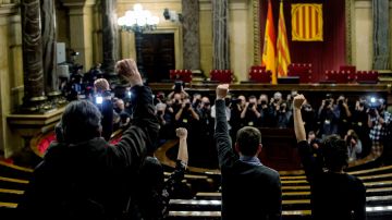 Los diputados de la CUP en sus escaños del Parlament a la hora prevista para iniciarse el pleno de investidura del próximo presidente de la Generalitat