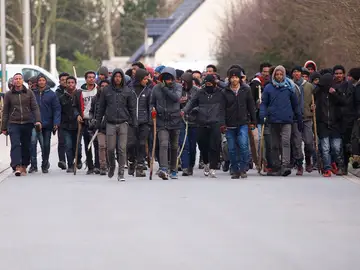 Un grupo de inmigrantes carga palos y piedras durante un enfrentamiento Un grupo de inmigrantes carga palos y piedras durante un enfrentamiento