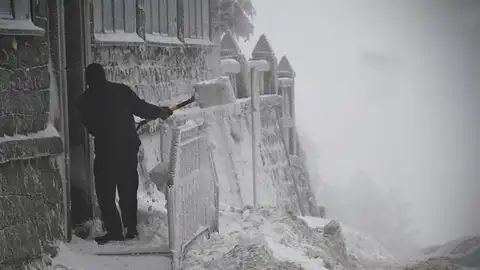 Un hombre retira la nieve de la puerta de una vivienda Un hombre retira la nieve de la puerta de una vivienda