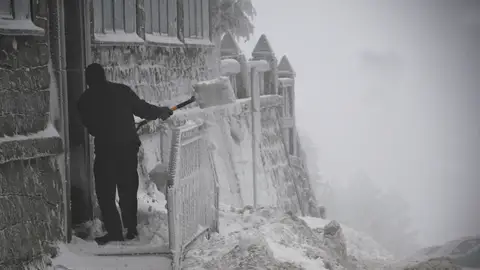Un hombre retira la nieve de la puerta de una vivienda esta mañana en el Puerto de Navacerrada Un hombre retira la nieve de la puerta de una vivienda esta mañana en el Puerto de Navacerrada
