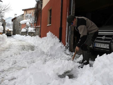 Un hombre quita la nieve de delante de su casa