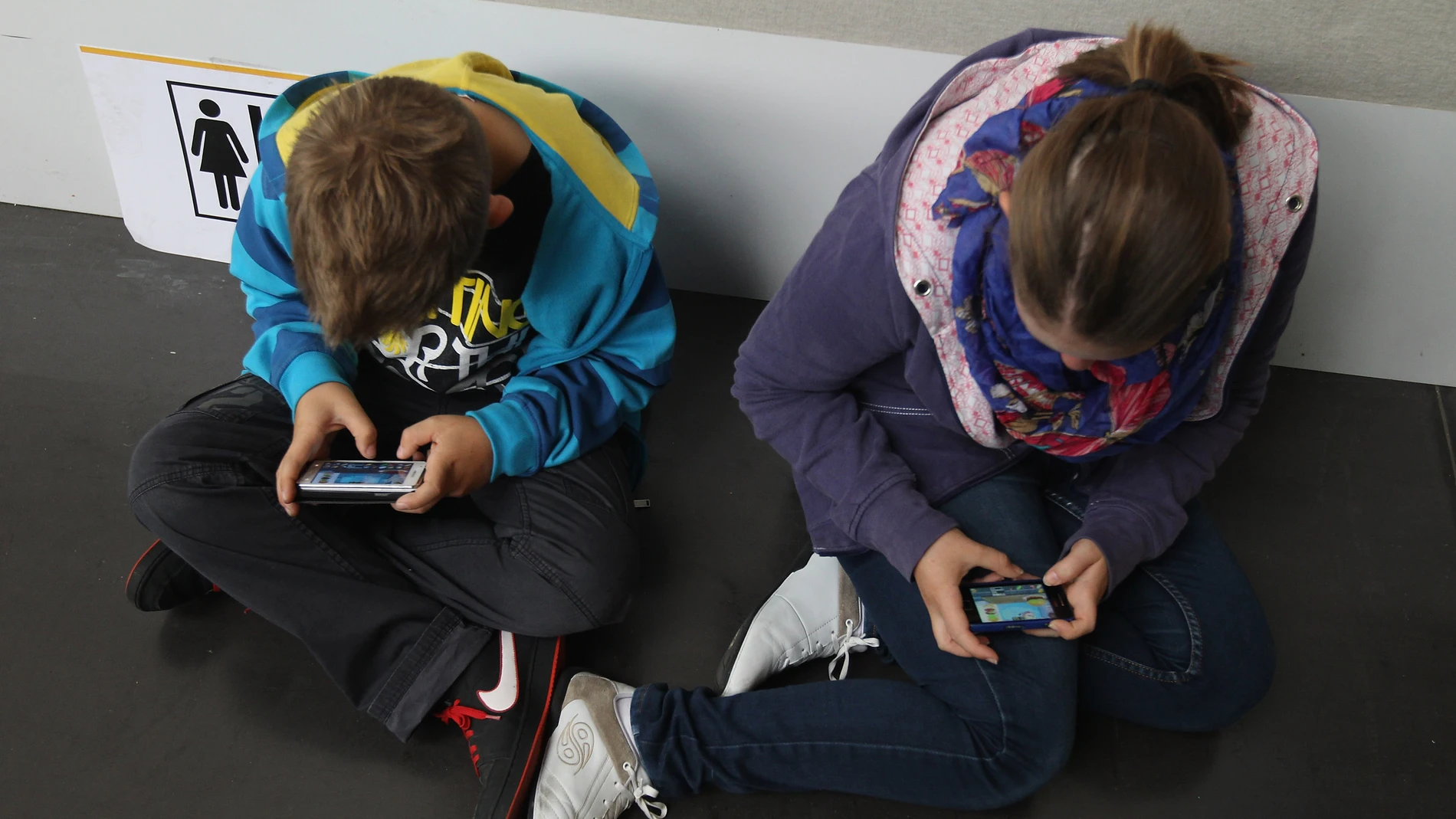Niños enganchados al teléfono móvil Niños enganchados al teléfono móvil