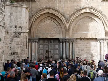 Visitantes esperan a la entrada del Santo Sepulcro, cerrando en Jerusalén Visitantes esperan a la entrada del Santo Sepulcro, cerrando en Jerusalén