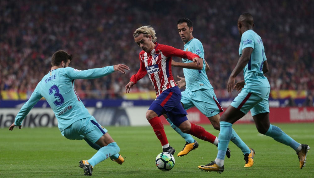 Griezmann intenta avanzar ante la defensa del Barcelona
