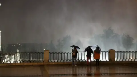 Varias personas observando las partículas de agua en suspensión debido al fuerte viento Varias personas observando las partículas de agua en suspensión debido al fuerte viento