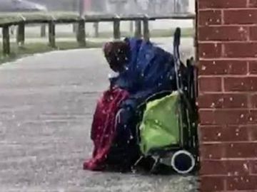 Un anciano se resguarda de la nieve en Reino Unido