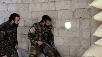 Soldados de las fuerzas gubernamentales sirias observan el corredor humanitario abierto 