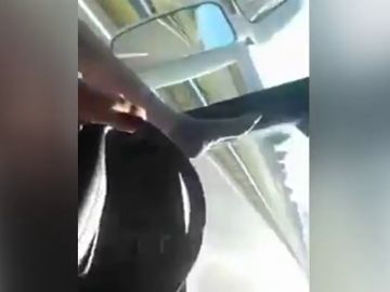 Un camionero se graba con el móvil mientras conduce con los pies en el salpicadero